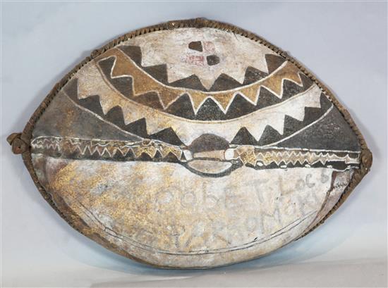 An elephant hide shield, with painted decoration and inscribed Robert Loc Kararromoki, 100cm